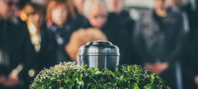 Image illustrant une cérémonie funéraire traditionnelle, avec des proches réunis autour d'une urne de crémation pour rendre hommage à leur être cher.